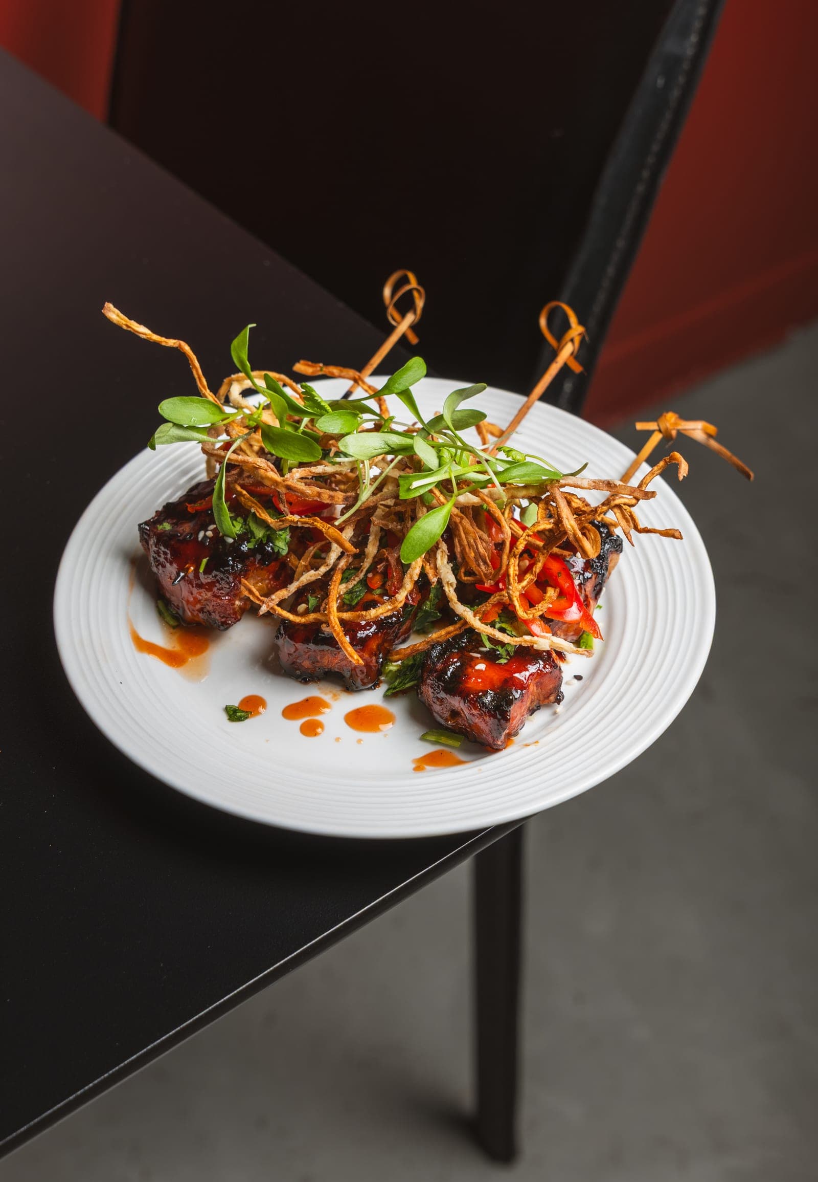 Glazed skewers under a nest of crisp sprouts