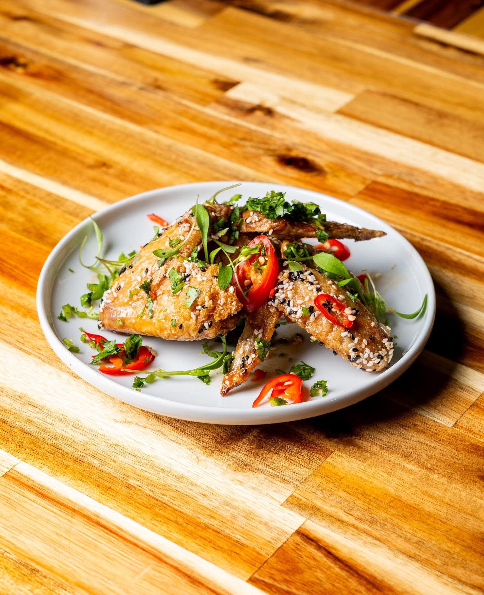 Delicate fish dish plated with herbs and chili