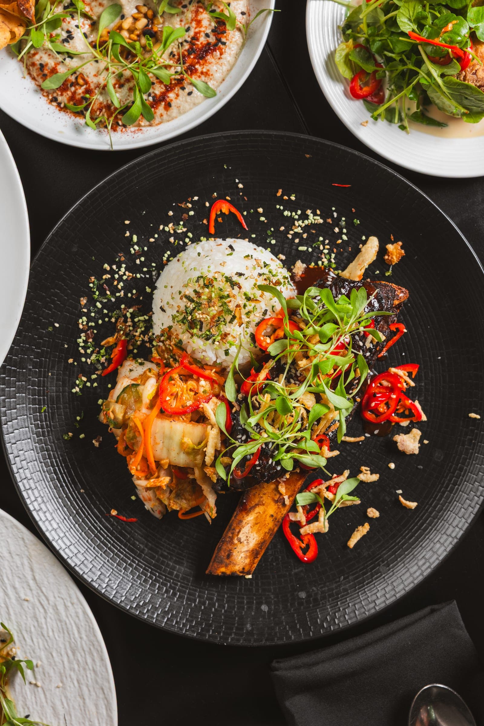 Charcoal-plated dish with steamed rice and herbs